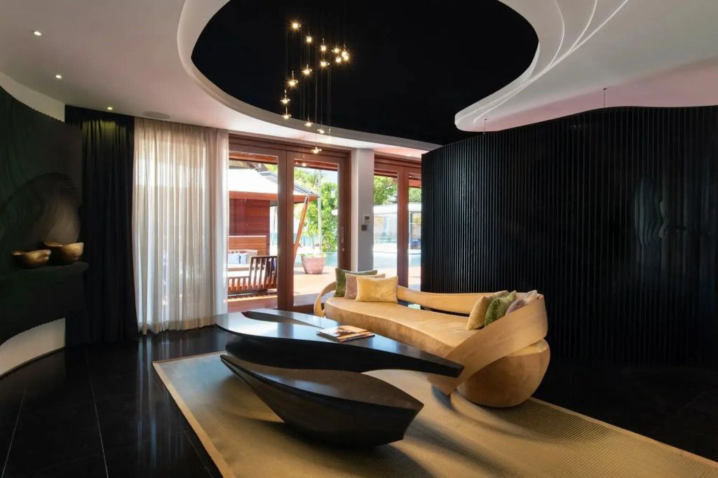 Moderne Lounge mit geschwungenen Möbeln und Blick auf den Außenbereich bei Tageslicht.