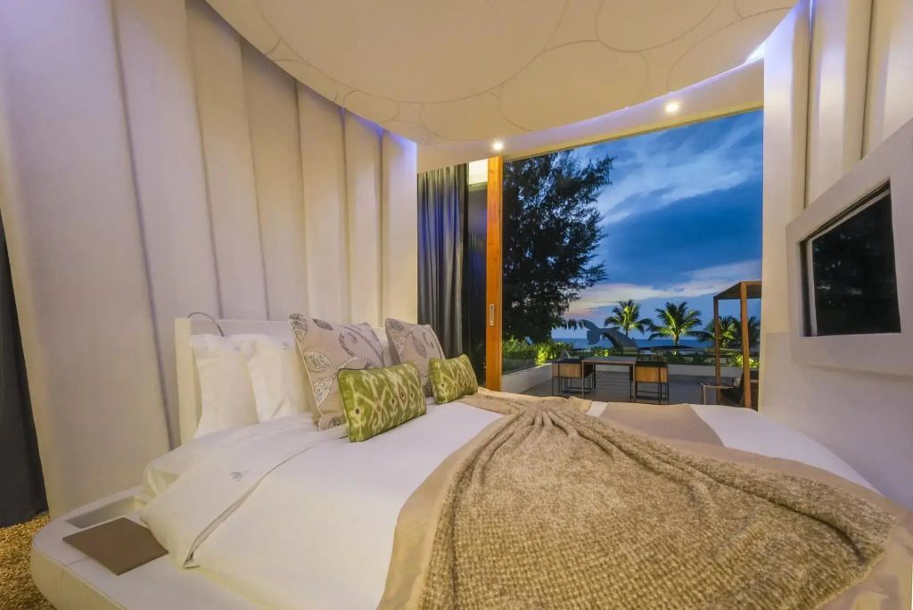 Luxuriöses Schlafzimmer mit Blick auf den Ozean bei Sonnenuntergang