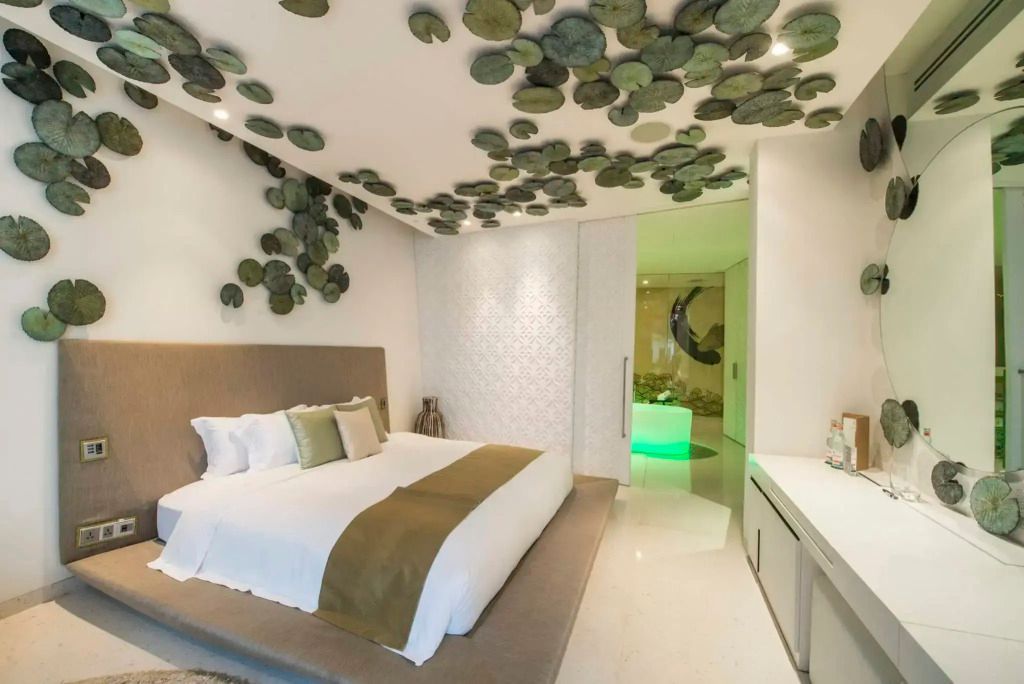 Luxuriöses Schlafzimmer mit großem Doppelbett und dekorativem Deckenmuster