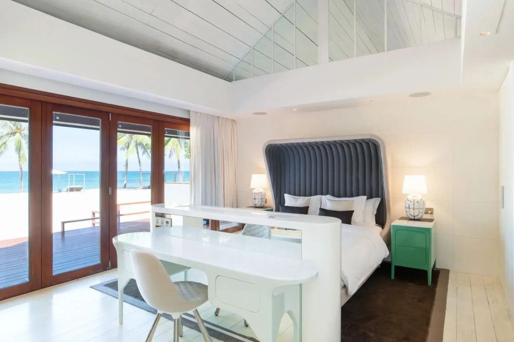 Lichtdurchflutete Suite mit Doppelbett und Glasschiebetüren zum Strand
