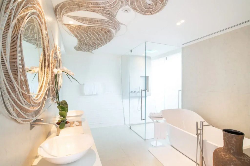 Modernes Badezimmer mit freistehender Badewanne und kunstvollen Deckenakzenten in der Siam Suite.