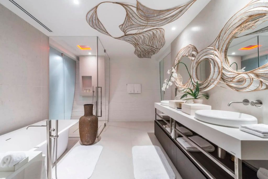 Geräumiges Badezimmer mit doppelten Waschbecken und moderner Duschkabine in der Siam Suite.