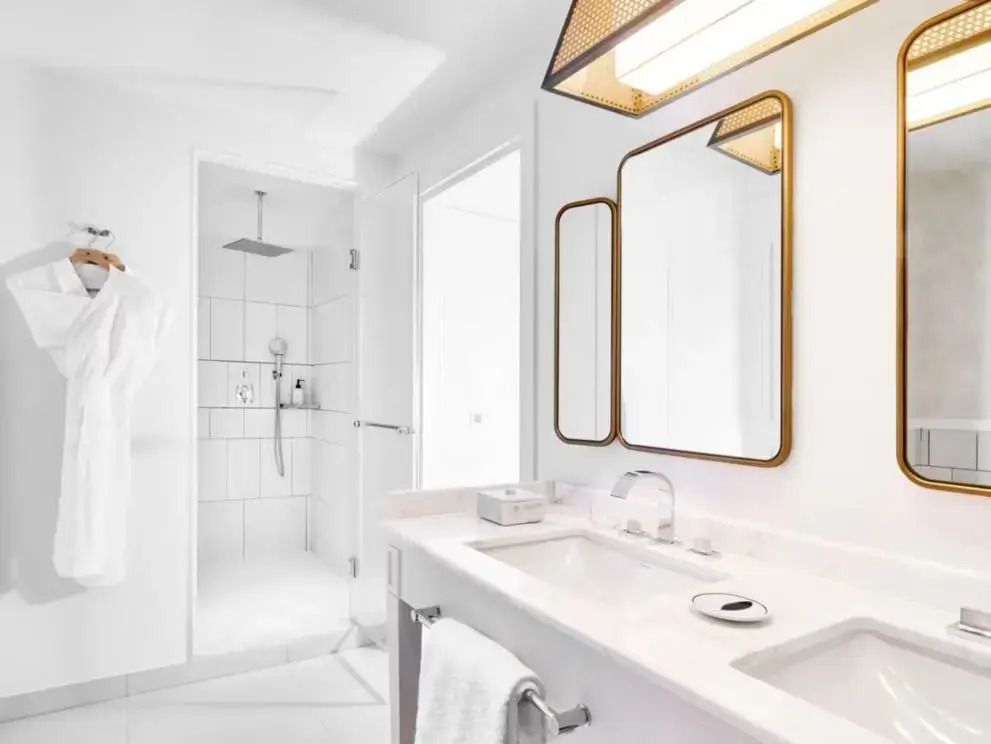 Modernes Badezimmer mit großem Spiegel und eleganten Armaturen.