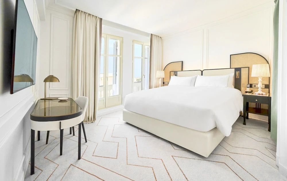 Helles klassisches Doppelzimmer mit großem Bett und Arbeitsbereich