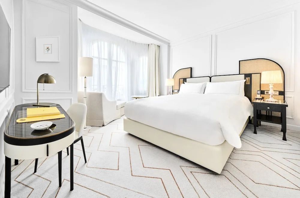 Elegantes Doppelzimmer mit Sitzecke und großen Fenstern