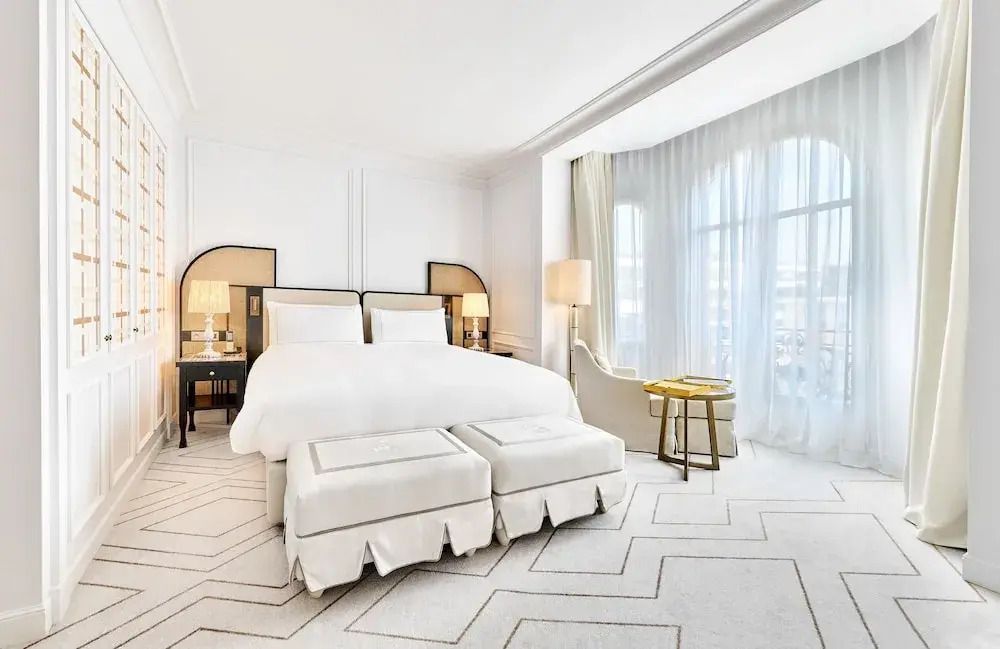 Geräumiges Hotelzimmer mit Doppelbett und modernem Interieur, Tageslicht durchflutet.