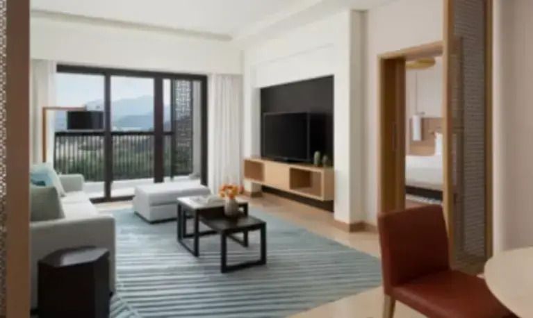 Großzügiges Wohnzimmer in Suite mit Fernseher, gemütlicher Sitzbereich, Bergblick.