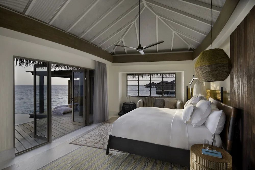Schlafzimmer einer Villa mit Bett und Blick auf das Meer