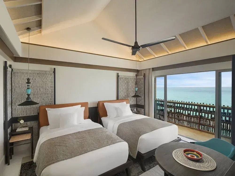 Zwei Einzelbetten in einem stilvollen Zimmer mit Blick auf das Meer