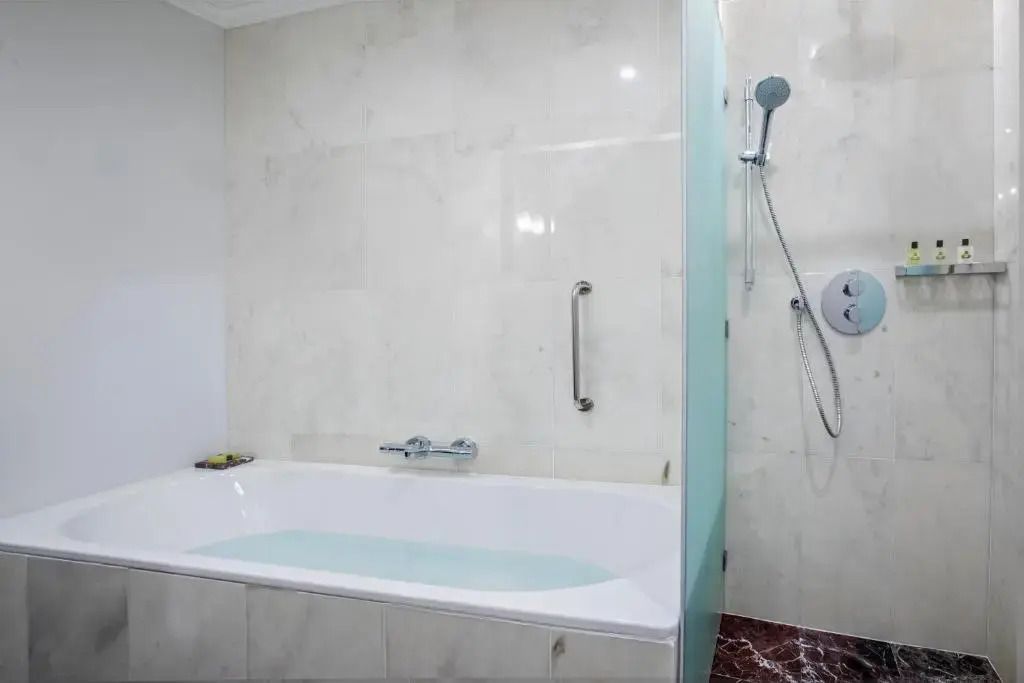 Modernes Badezimmer mit Badewanne, Dusche und Marmorboden
