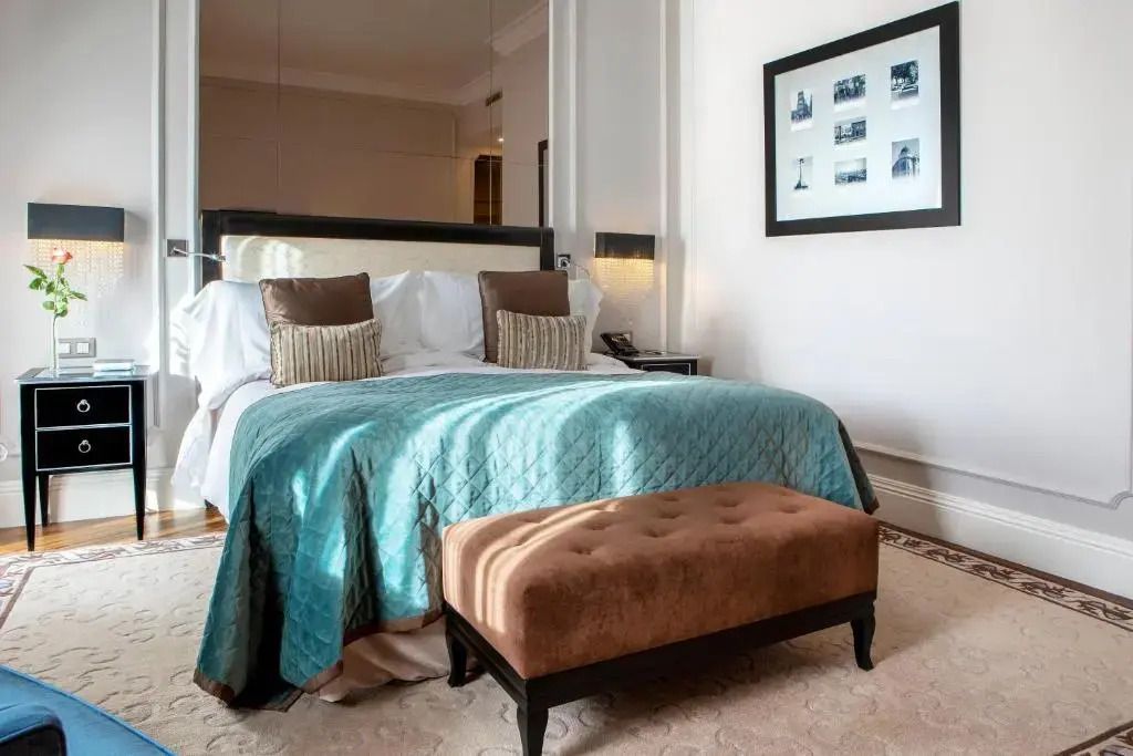 Elegantes Doppelbettzimmer mit blauem Überwurf und stilvollen Kissen.