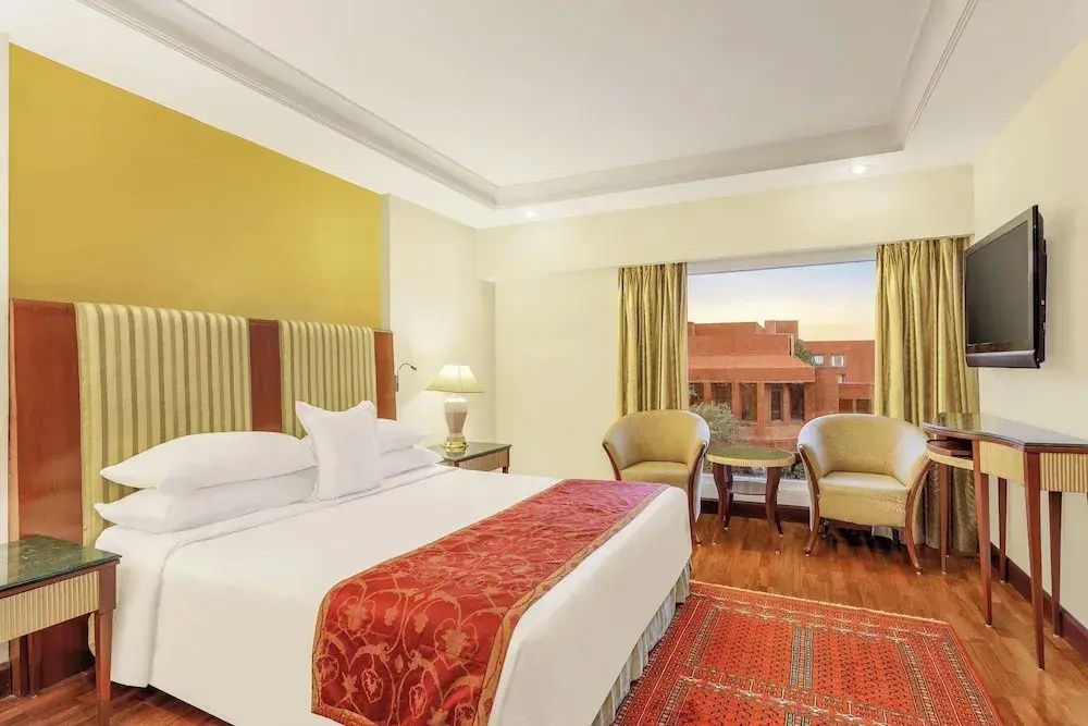 Helles Schlafzimmer mit großem Bett und Aussicht auf historische Architektur