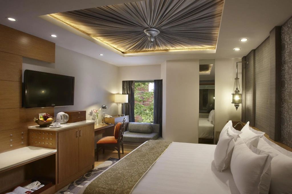 Gemütliches Zimmer im ITC Mughal Hotel mit elegantem Design und Gartenblick.