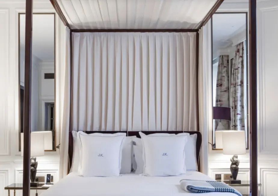 Luxuriöses Bett mit Baldachin und eleganter Bettwäsche in der Suite