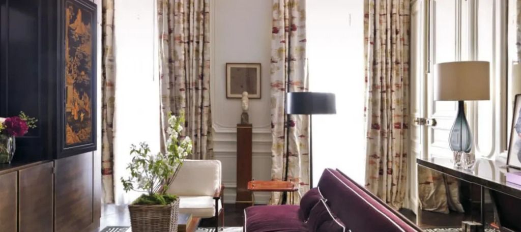 Gemütliche Sitzecke mit violettem Sofa und dekorativen Vorhängen