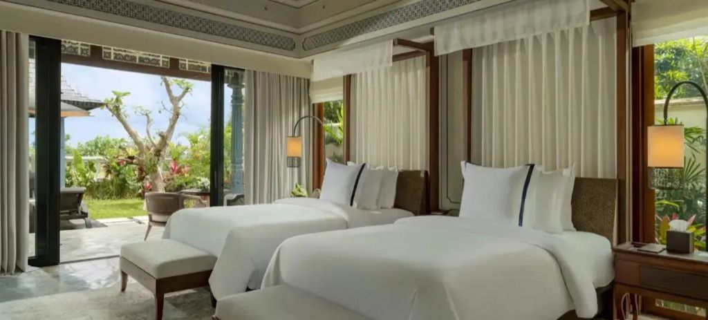 Luxuriöses Schlafzimmer mit zwei Betten und Blick auf den Garten