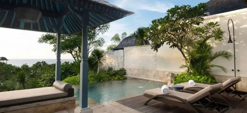 Privater Pool mit Liegestühlen und tropischer Kulisse im Hintergrund