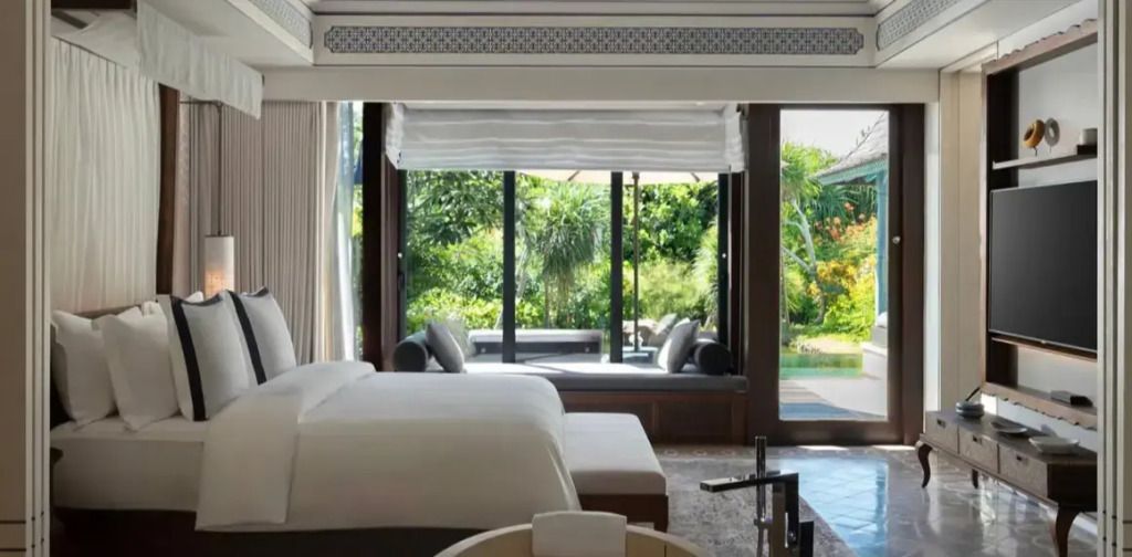 Luxuriöse Villa mit Doppelbett und Blick auf privaten Garten und Pool