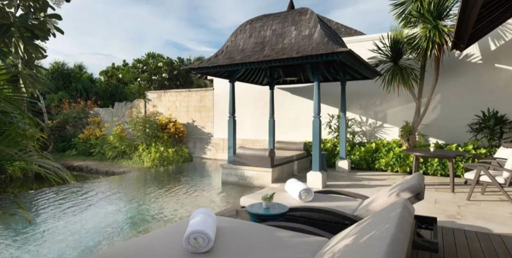 Privater Poolbereich mit Pavillon und Liegestühlen in tropischem Garten