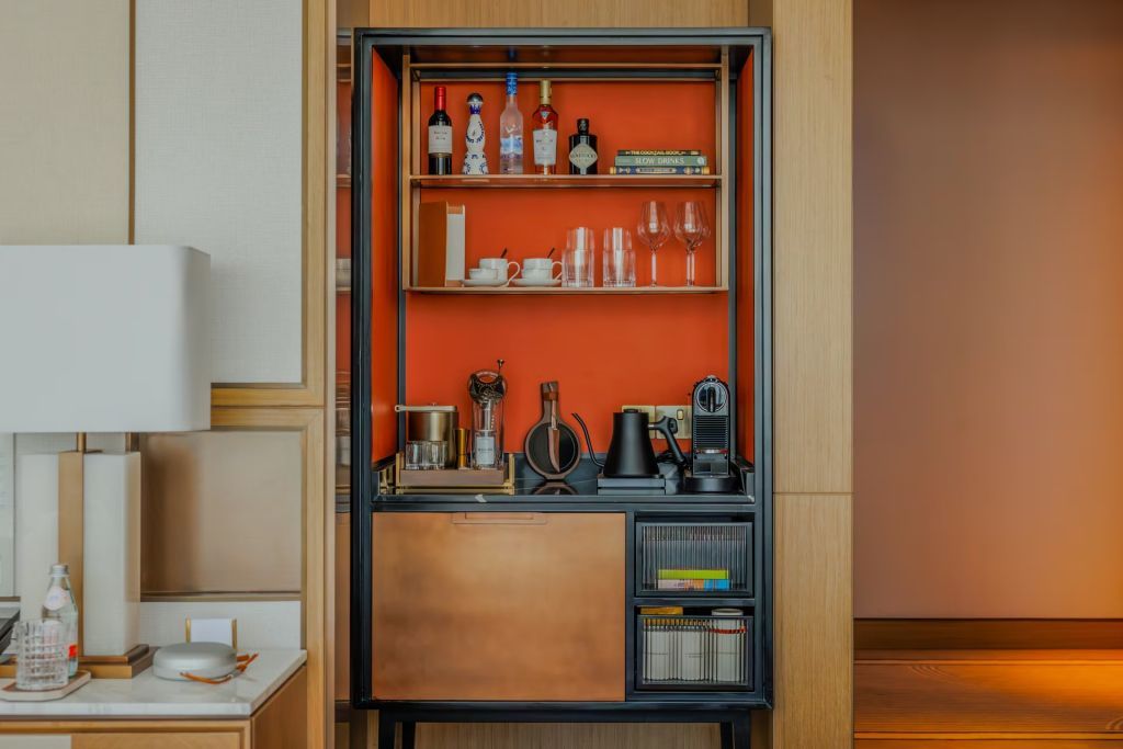 Moderne, gut ausgestattete Minibar mit hochwertigen Getränken und stilvollen Regalen.