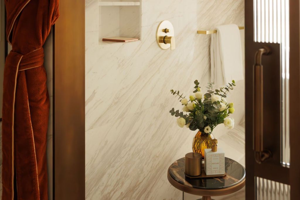 Elegantes Badezimmer mit Blumenarrangement und goldenen Akzenten
