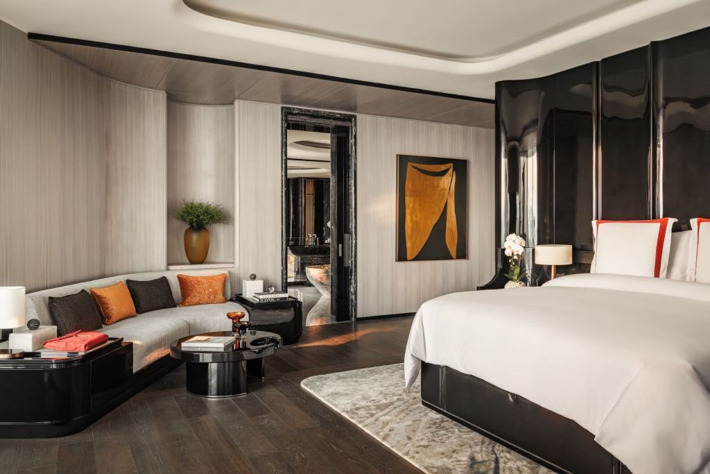 Suite mit moderner Kunst, gemütlichem Sofa und großem Bett in der Pearl Suite