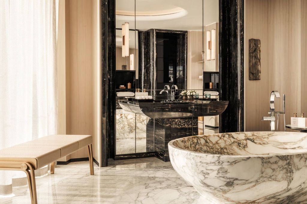 Marmorbadezimmer mit eleganter Badewanne und großen Spiegeln in der Pearl Suite