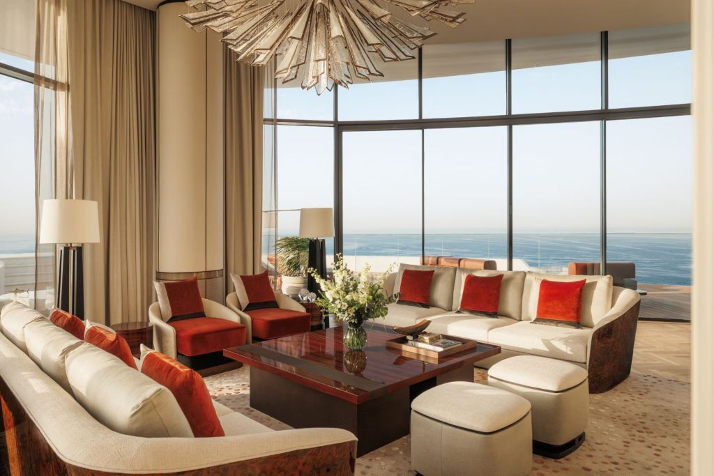 Weitläufiges Wohnzimmer mit Panoramafenstern und Blick auf das Meer.