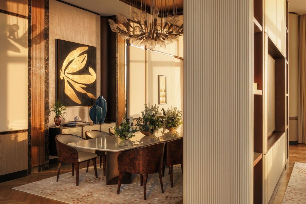 Hochwertig eingerichtetes Esszimmer mit großem Tisch und kunstvollen Dekorationen.