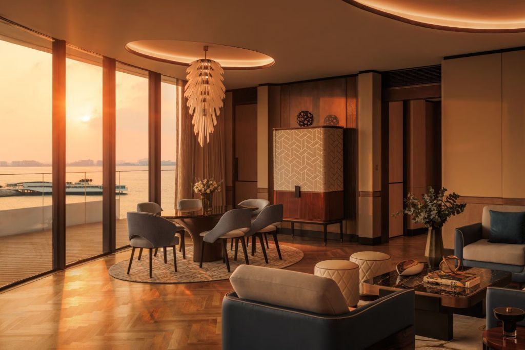 Wohnbereich in der Suite mit modernen Möbeln und Aussicht auf das Meer bei Sonnenuntergang
