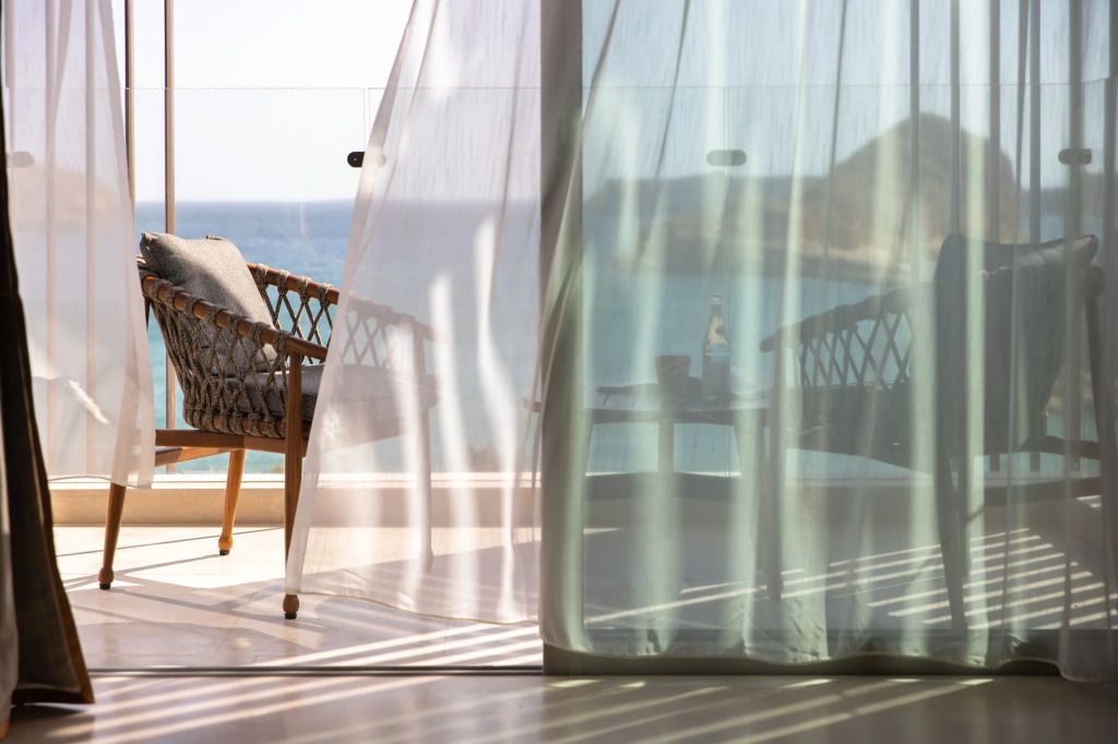 Blick vom Balkon auf das Meer durch transparente Vorhänge im Jumeirah Muscat Bay