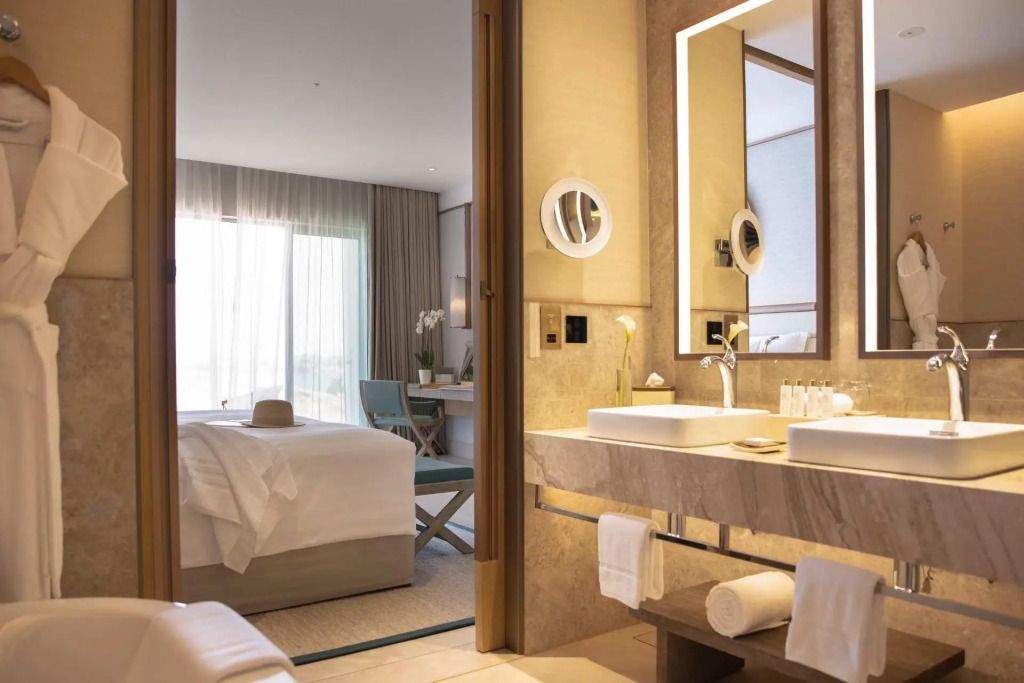 Geräumiges Hotelzimmer mit modernem Badezimmer und eleganter Beleuchtung.