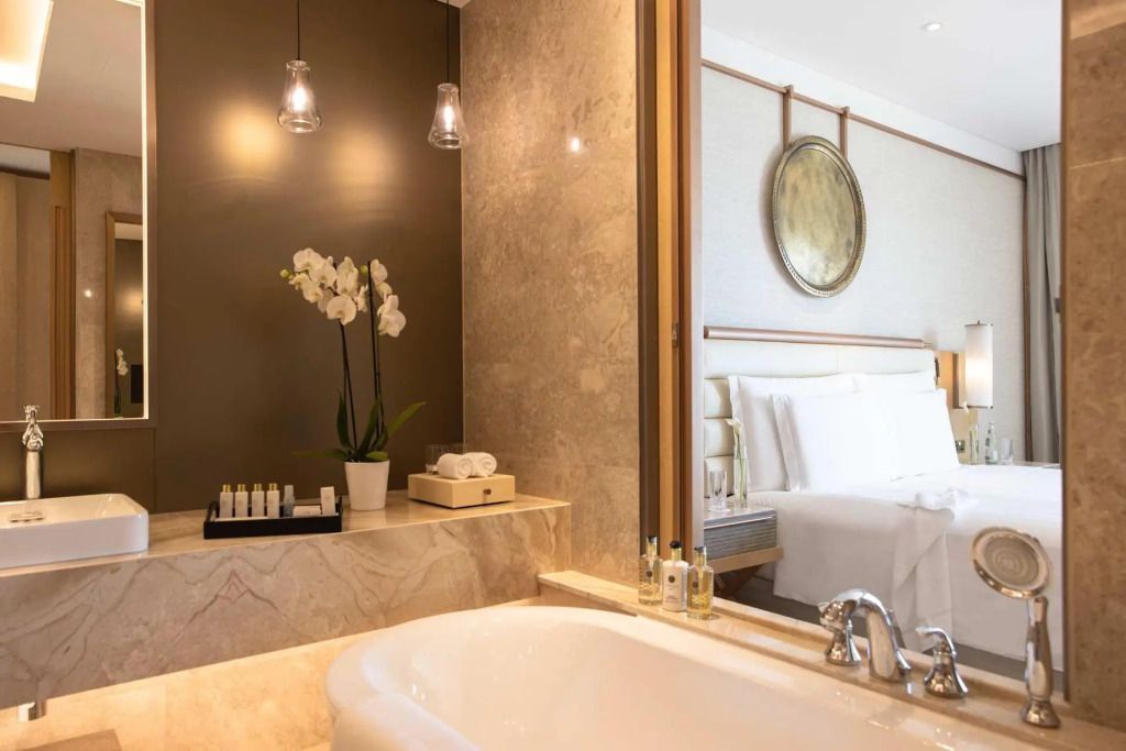 Luxuriöses Badezimmer mit Badewanne und Orchidee auf Marmorablage