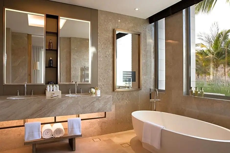 Luxuriöses Badezimmer mit freistehender Badewanne und großer Spiegelwand