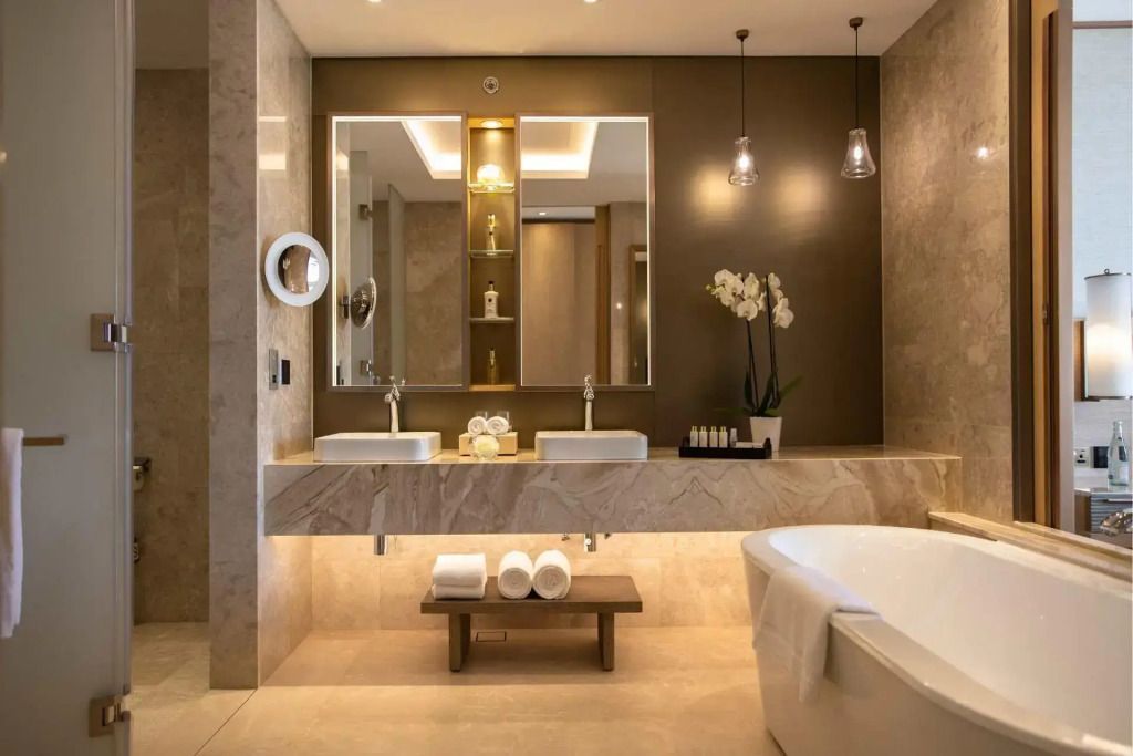 Luxuriöses Badezimmer der Suite mit Doppelwaschtisch und freistehender Badewanne.