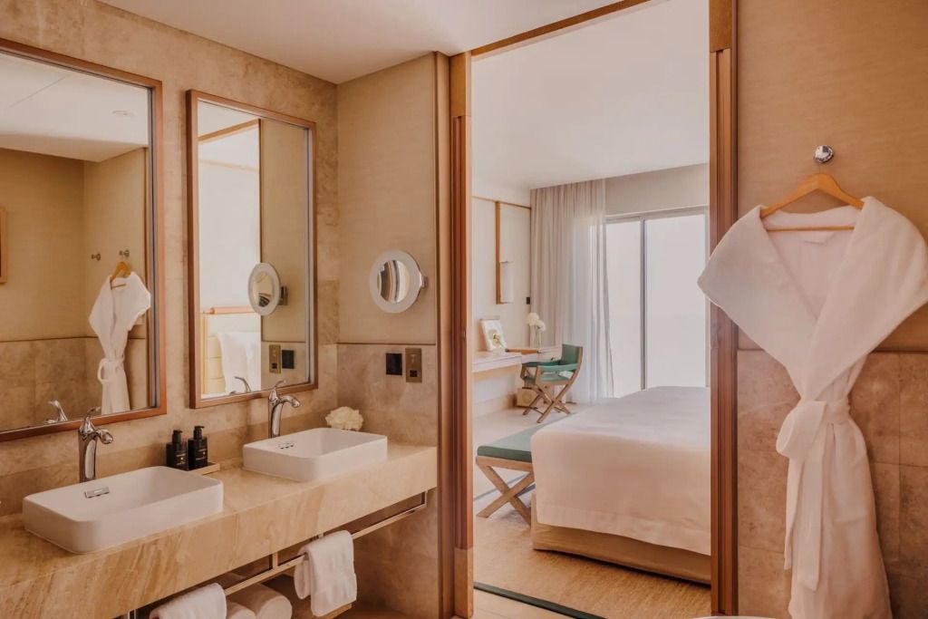 Offenes Badezimmer mit modernen Armaturen und Blick ins Schlafzimmer