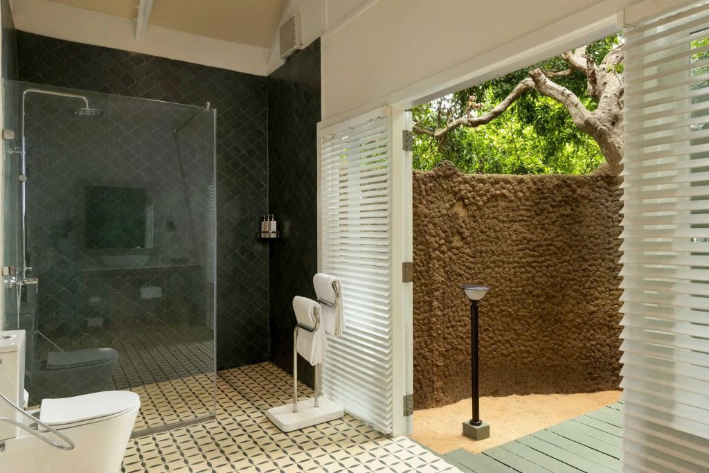 Dusche in luxuriösem Badezimmer mit gemustertem Boden und natürlichem Licht