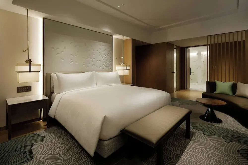 Gemütliches Schlafzimmer in warmen Tönen mit charmantem Beleuchtungsdesign im JW Marriott Hotel Nara
