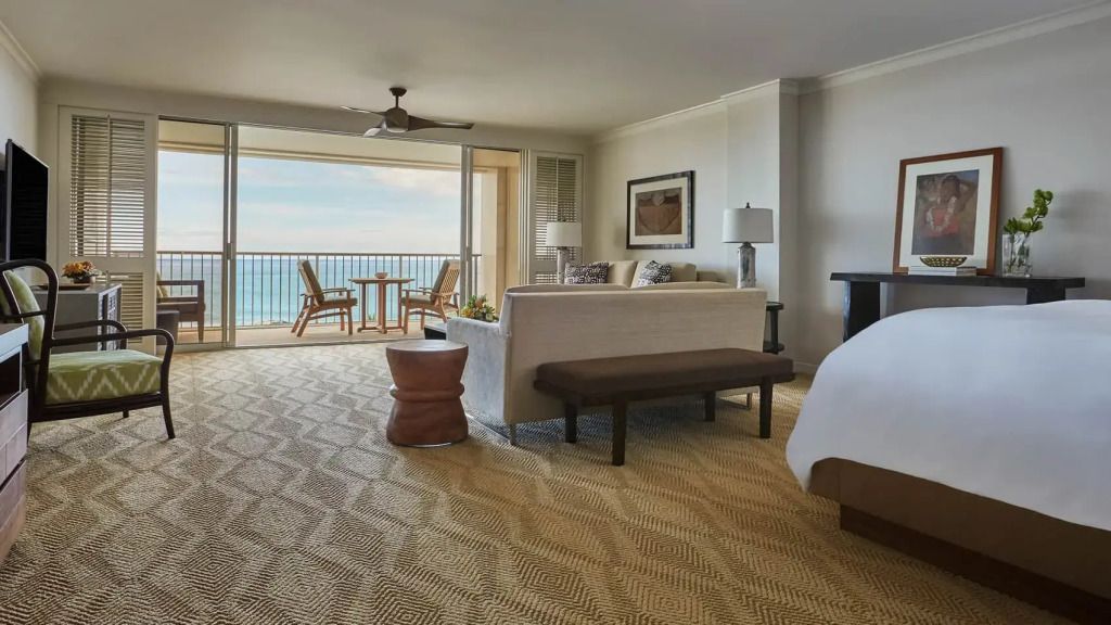 Großzügige Suite mit Blick auf das Meer. Helle Einrichtung und offener Balkon mit Sitzgelegenheit.