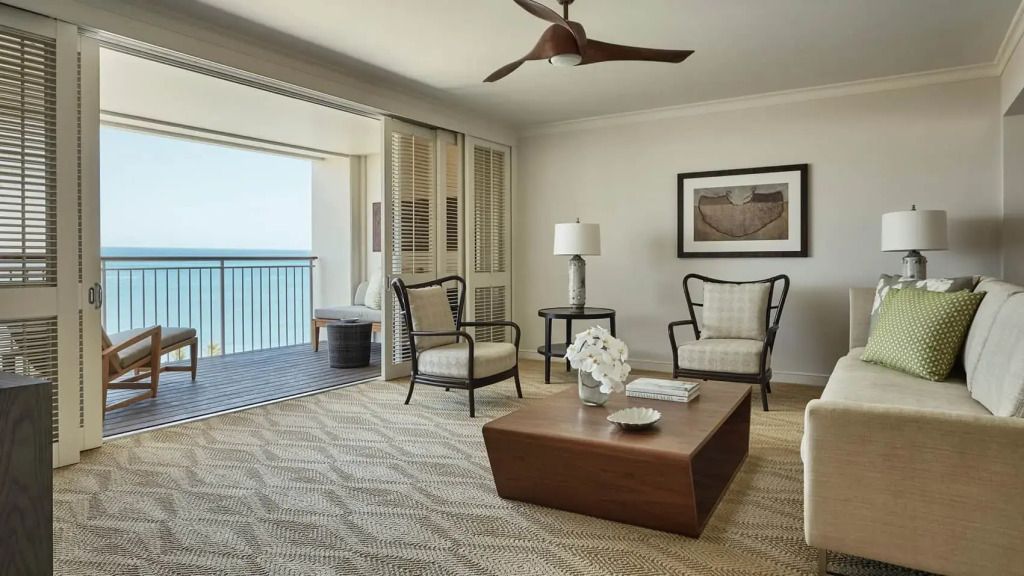 Wohnzimmer mit hellem modernen Design und Zugang zu einem offenen Balkon mit Meerblick.