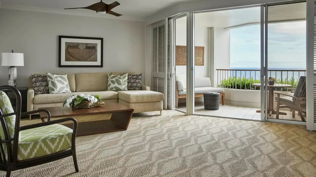 Geräumiges Wohnzimmer in der Suite mit Balkon und Meerblick im Four Seasons Oahu.