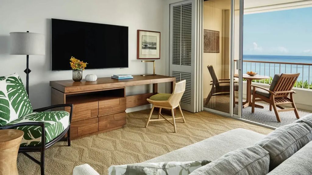 Zimmeransicht mit moderner Einrichtung, Fernseher und Zugang zum Balkon im Four Seasons Resort.