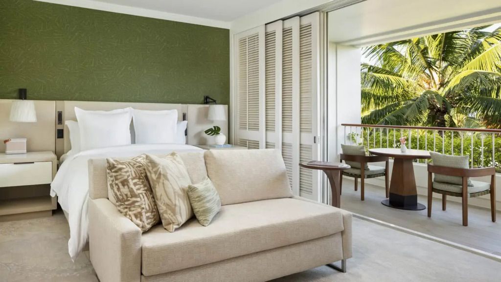 Elegantes Doppelzimmer mit Sofa und Balkon Blick auf Palmen und Meer