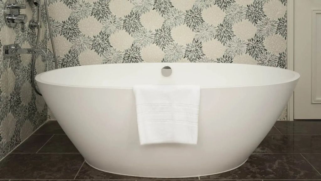 Freistehende Badewanne vor einer dekorativen Tapete