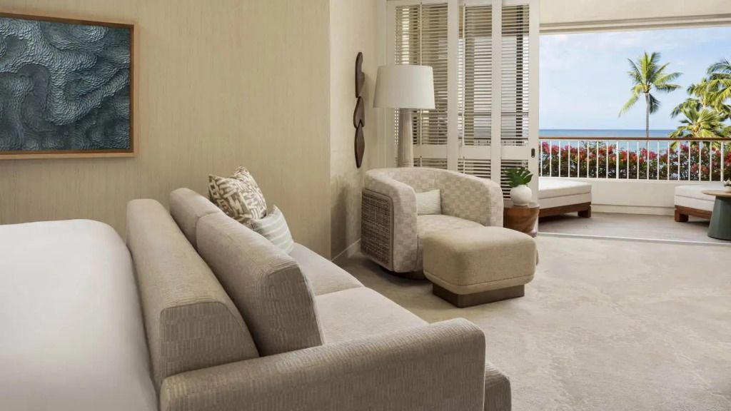 Elegantes Wohnzimmer einer Suite mit modernem Sofa und Meerblick.