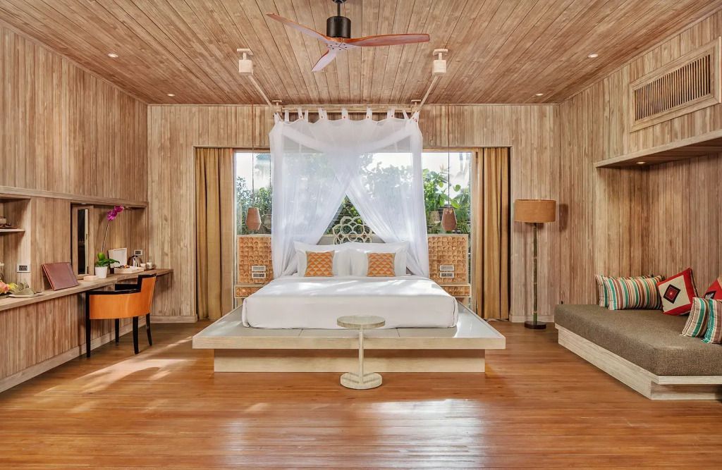 Geräumiges Schlafzimmer mit Himmelbett und Holzdetails im luxuriösen Resort