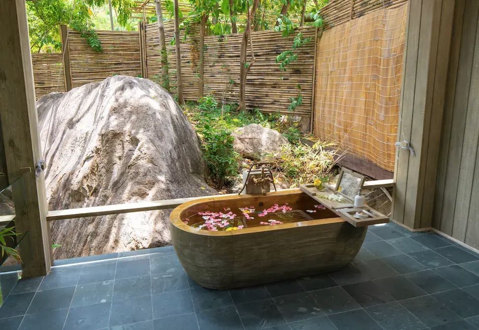 Freistehende Badewanne im privaten Outdoor-Bereich mit natürlichem Ausblick