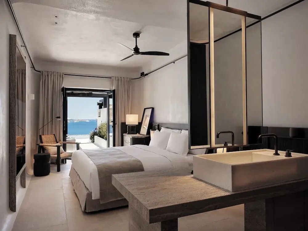 Edle Junior-Suite mit modernem Design und Blick auf das Meer von einem Balkon.
