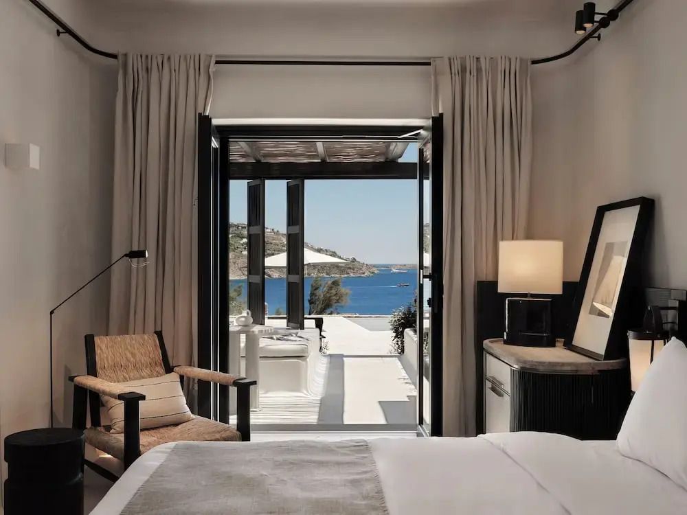 Luxuriöses Zimmer mit offenem Zugang zum Balkon und Meerblick in der Ferne.