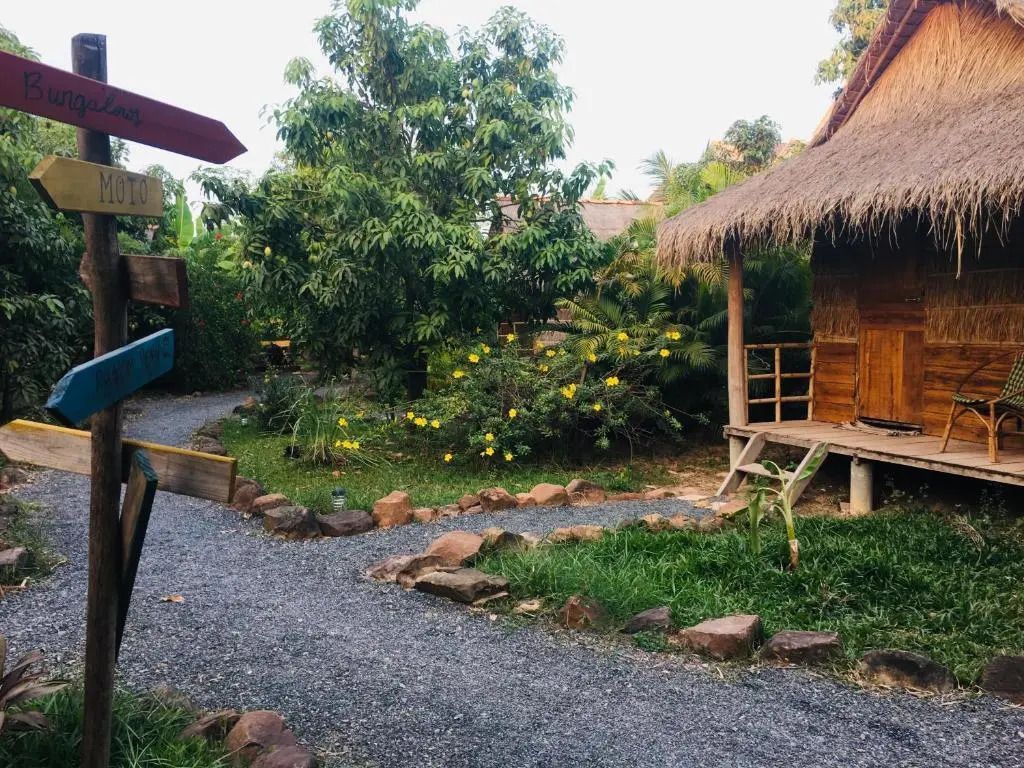 Gartenpfad neben einem traditionellen Bungalow mit Strohdach